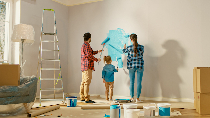 mother and father painting living room wall together