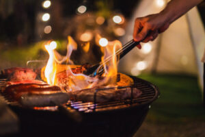 Person uses barbecue grill in summertime.