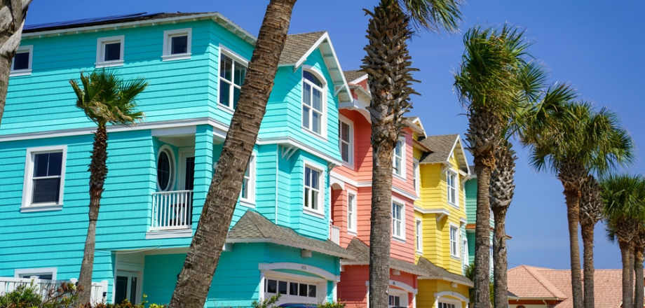 colorful Florida beach homes nestled by row of palm trees