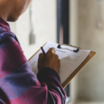 Home inspector takes notes during an interior home inspection for insurance coverage.