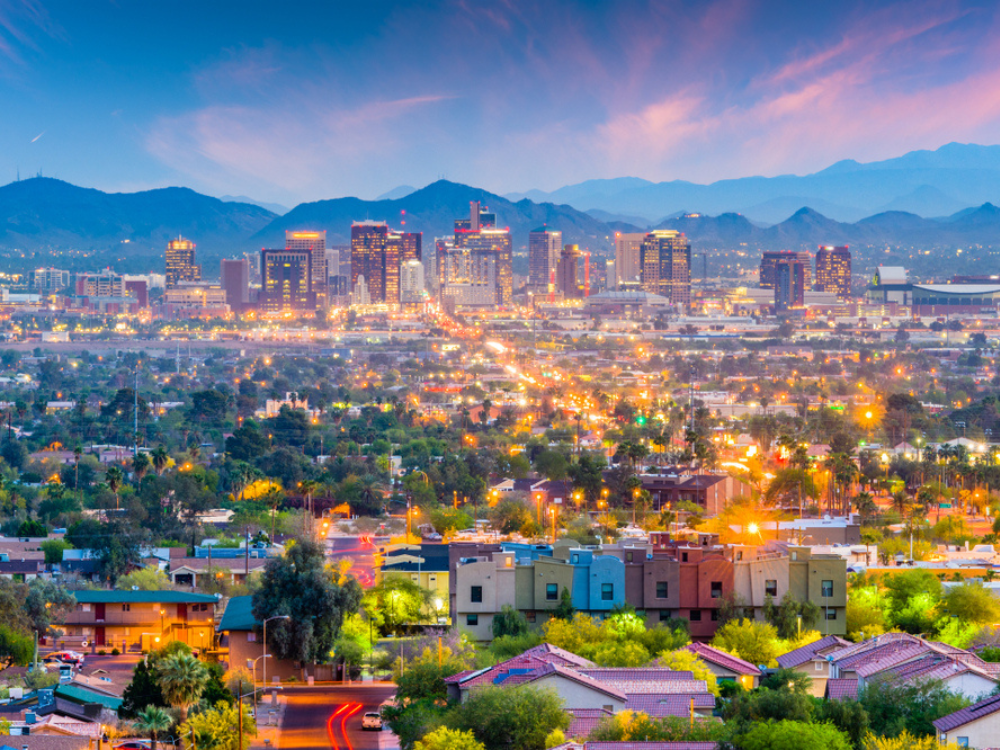 Downtown Phoenix, AZ, skyline with mountains shown at sunset.