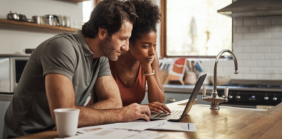 Couple looks at their credit scores on a laptop computer during a research for homeowners insurance options.