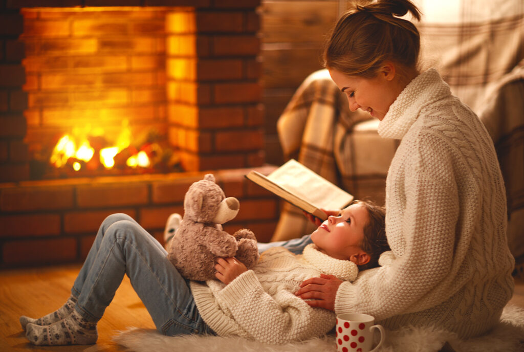 family by fireplace reading