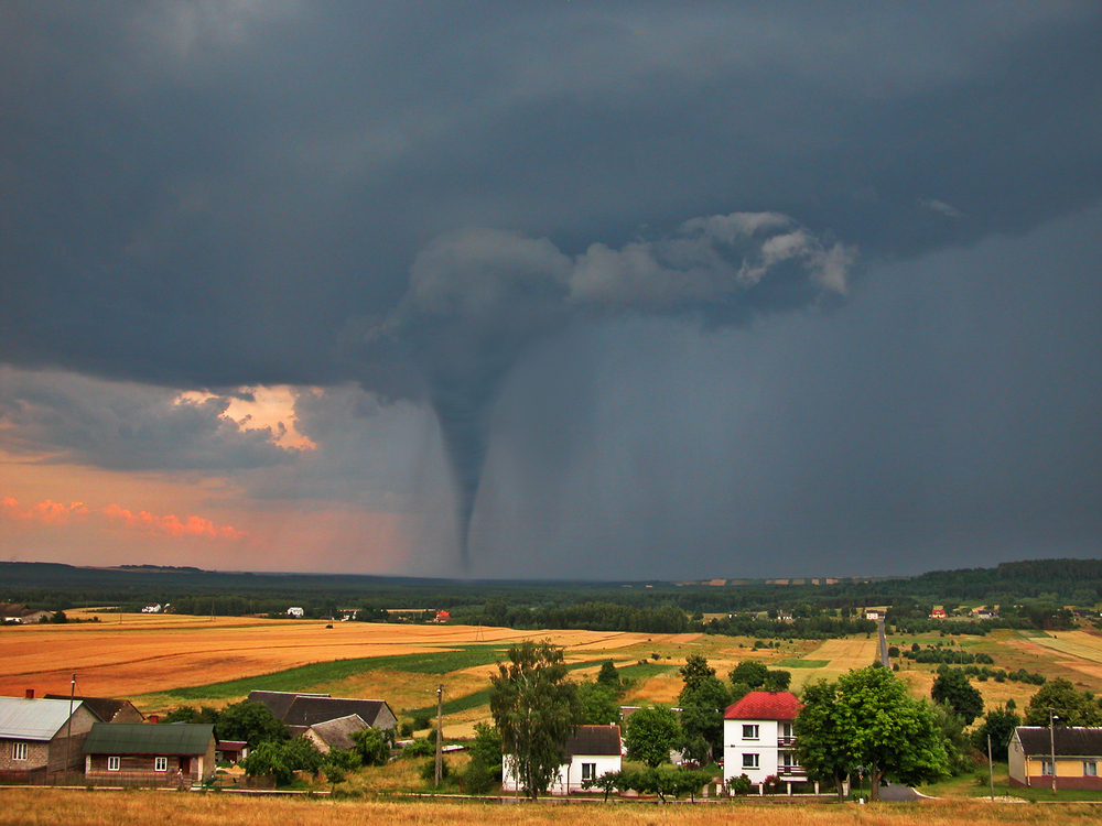 Tornado is shown in the distance of a countryside under a tornado warning.